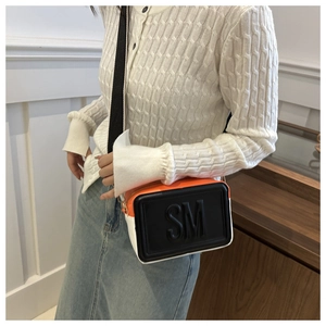 Detail of tricolor crossbody bag with embossed SM letters and black wide fabric strap