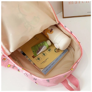 Interior view of pink cartoon backpack showing capacity for notebooks and water bottles