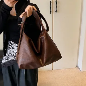 Brown leather tote bag for women featuring a minimalist design and large capacity