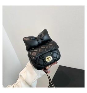 Detailed close-up of a black quilted crossbody bag with a large decorative bow and gold lock