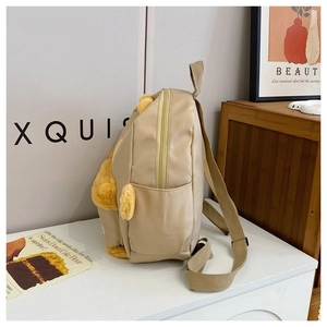 Detailed side view of beige backpack featuring yellow plush bear ears and paw accents