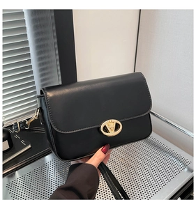 Gros plan du sac porté épaule noir mat avec un fermoir doré et des coutures de précision