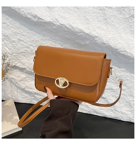 Détail du sac caramel avec fermoir ovale doré et texture de cuir synthétique fin