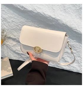 Détail du sac à bandoulière en similicuir blanc crème avec boucle en métal doré en V