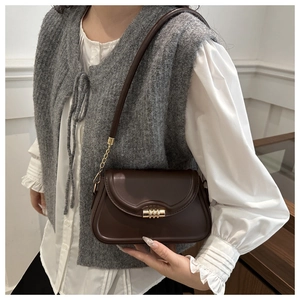 Detail shot of vintage dark brown faux leather bag with elegant gold metal twist lock