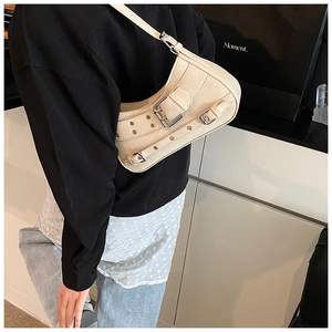 Chic cream half-moon underarm bag with silver buckles and rivets on model