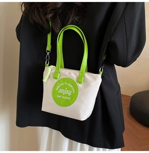 Détail du sac en nylon contrasté avec poignées en cuir vert et étiquette design