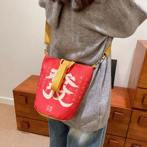 Detail einer roten Canvas-Beuteltasche mit weißer Kalligrafie und gelbem Gurtband