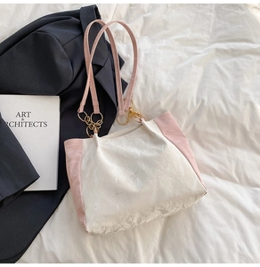 Detailed view of white textured fabric and pink straps on a casual minimalist tote bag