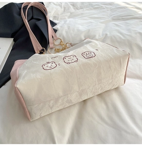 Detail of cute bear print tote bag with soft pleated fabric and pink shoulder straps