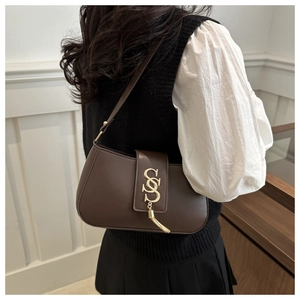 Chic brown leather crescent bag featuring a gold metal S-hardware and tassel detail