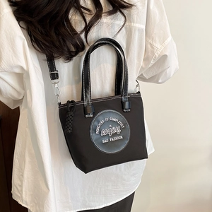 Grand sac fourre-tout noir en nylon avec logo blanc vu de profil arrière sur le mannequin