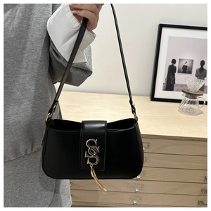 Detail of black crescent shoulder bag with golden S-buckle and elegant metal tassel