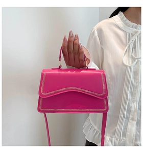 Detail of hot pink shoulder bag with decorative woven stitching and top handle