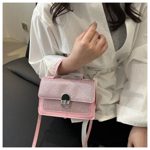 Detailed shot of pink sequined crossbody bag with metallic lock and leather handle