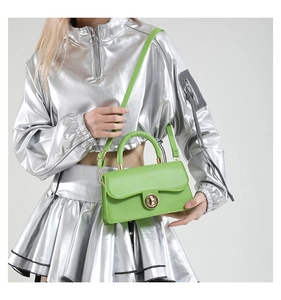 Detail of lime green crossbody bag with gold round lock and textured leather finish