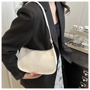 Close-up of white crocodile pattern shoulder bag featuring refined texture and zip closure