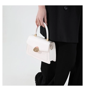 Detail of white crocodile-embossed flap bag with gold metal buckle and smooth PU finish