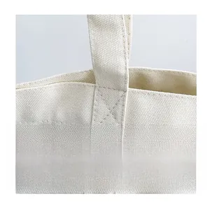 Close-up of reinforced X-shaped cross-stitching on durable canvas tote bag handle