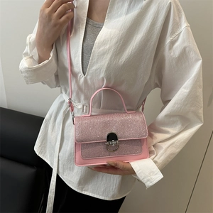 Pink sequin crossbody handbag with silver swivel lock shown on model for size perspective