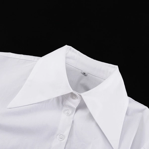 Détail du col pointu et des boutons d'un chemisier blanc court avec étiquette taille M