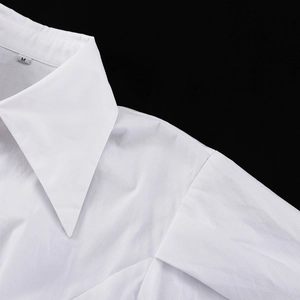 Gros plan d'une chemise courte blanche montrant les détails du col et des coutures
