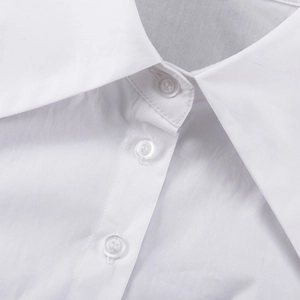 Détail du col classique et des boutons sur une chemise courte blanche à manches longues