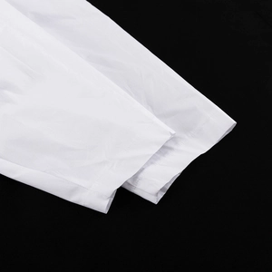 Gros plan détaillé des poignets en coton blanc montrant les coutures et la texture du tissu