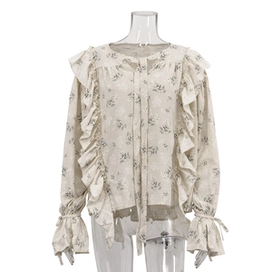 French style floral blouse with ruffles and lace-up bell sleeves on white mannequin