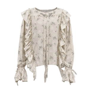 Detail of floral print blouse showing ruffles, bow tie neckline, and flare sleeves