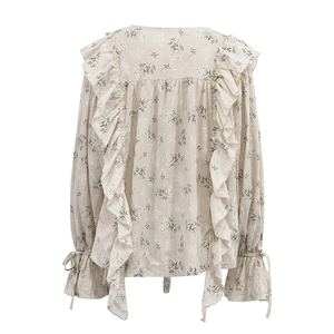 Detail view of floral long-sleeve blouse with ruffles and tie-up cuffs in French style