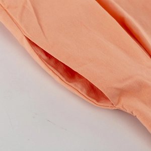 Detail der Seitentasche an der orange-rosa Baumwoll-Leinen-Hose mit feiner Textur