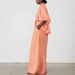 Detail eines orange-rosa Zweiteilers mit Puffärmeln und weiter Hose für Damen