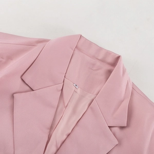 Detail eines rosa Blazer-Revers mit eingenähtem S-Etikett und hochwertigem Stoff