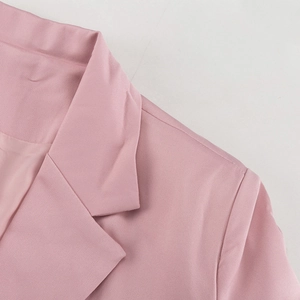 Detail von rosa Blazer-Revers und Schulternaht-Stickerei am Damen-Hosenanzug