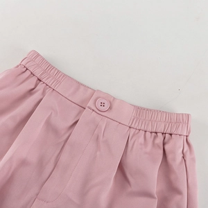 Detailansicht der rosa Hose mit elastischem Bund und passenden dekorativen Knöpfen