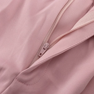 Detail eines SBS-Reißverschlusses an einem rosa Anzug mit feiner Twill-Struktur