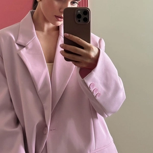Spiegel-Selfie zeigt Details eines hellrosa Oversize-Blazers mit dreiköpfigen Manschetten