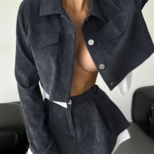 Detalle de chaqueta de pana gris oscuro con botones metálicos y bolsillos con solapa
