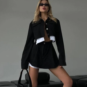 Conjunto de dos piezas estilo urbano con chaqueta corta negra y falda de contraste