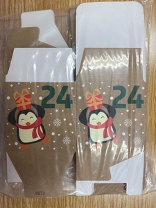 Flat kraft paper Christmas advent box with penguin motif and green number 24 detail