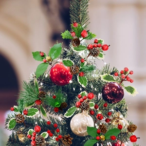 Close-up of red berries, pine cones and frosted holly leaves on a Christmas tree