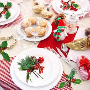 Close-up of DIY Christmas decorations with pine needles, red berries and festive bows