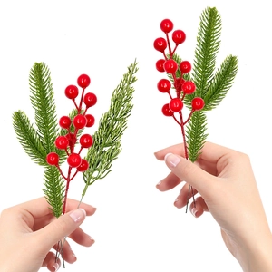 Detail of lifelike artificial pine needles and red berries for festive Christmas table decor
