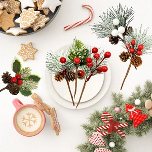 Flat lay of artificial Christmas berry stems with pine cones and snowflake needles decoration