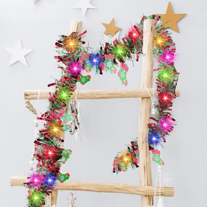 LED Christmas tinsel garland with colorful lights and snowflake stockings on wood ladder