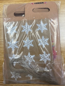 Detail of Christmas kraft paper gift box set with snowflake tag and natural jute twine