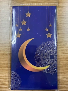 Detail of dark blue festive envelope with gold crescent moon and mandala pattern packaging