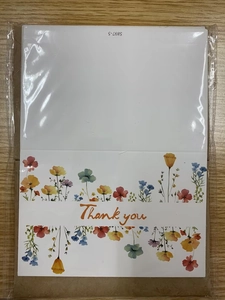 Détail de cartes de remerciement fleurs sauvages dans un emballage sur surface en bois