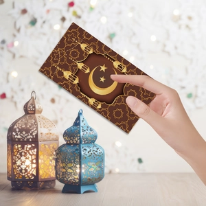 Macro detail of Ramadan Eid green envelopes with gold foil Islamic patterns and crescent moon